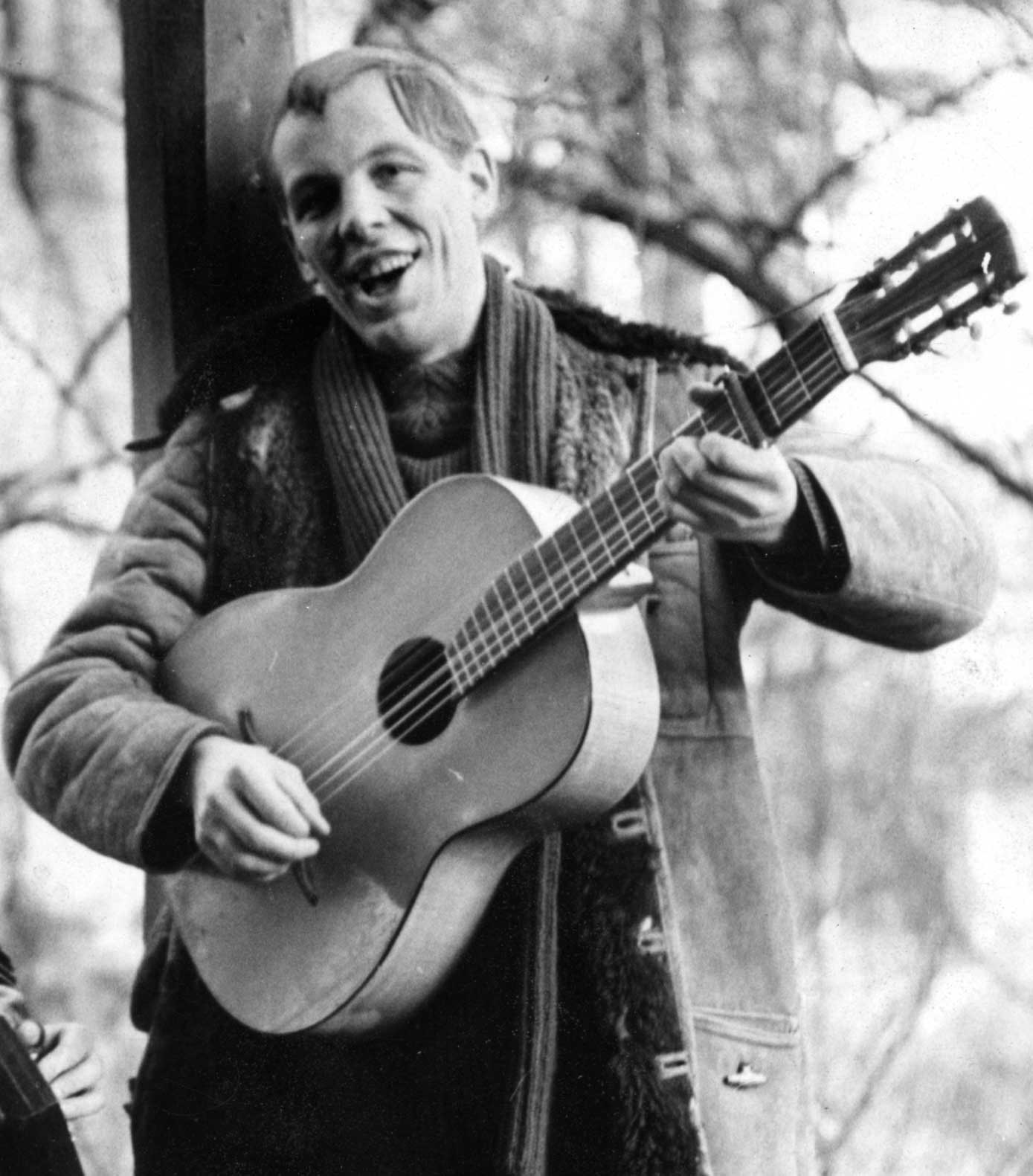 Peter Rohland steht und singt und spielt dazu auf einer hölzernen Gitarre.